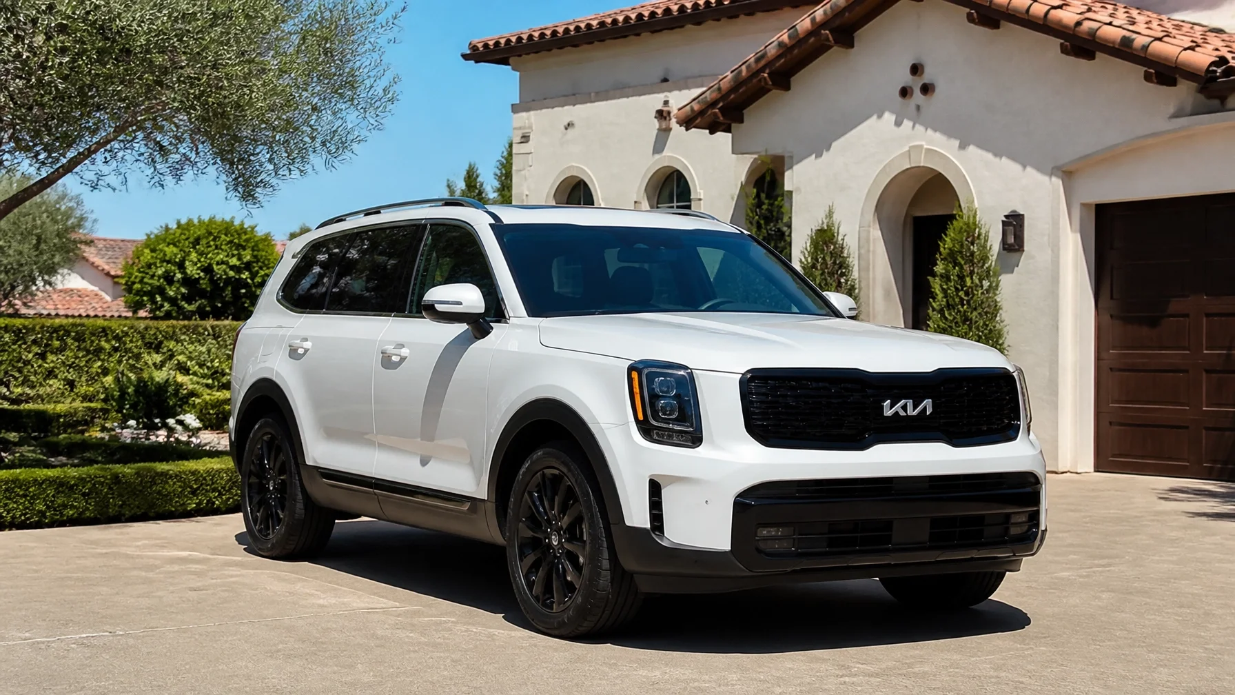 A white Kia Telluride parked in a sun-drenched Roseville driveway during a hot July afternoon